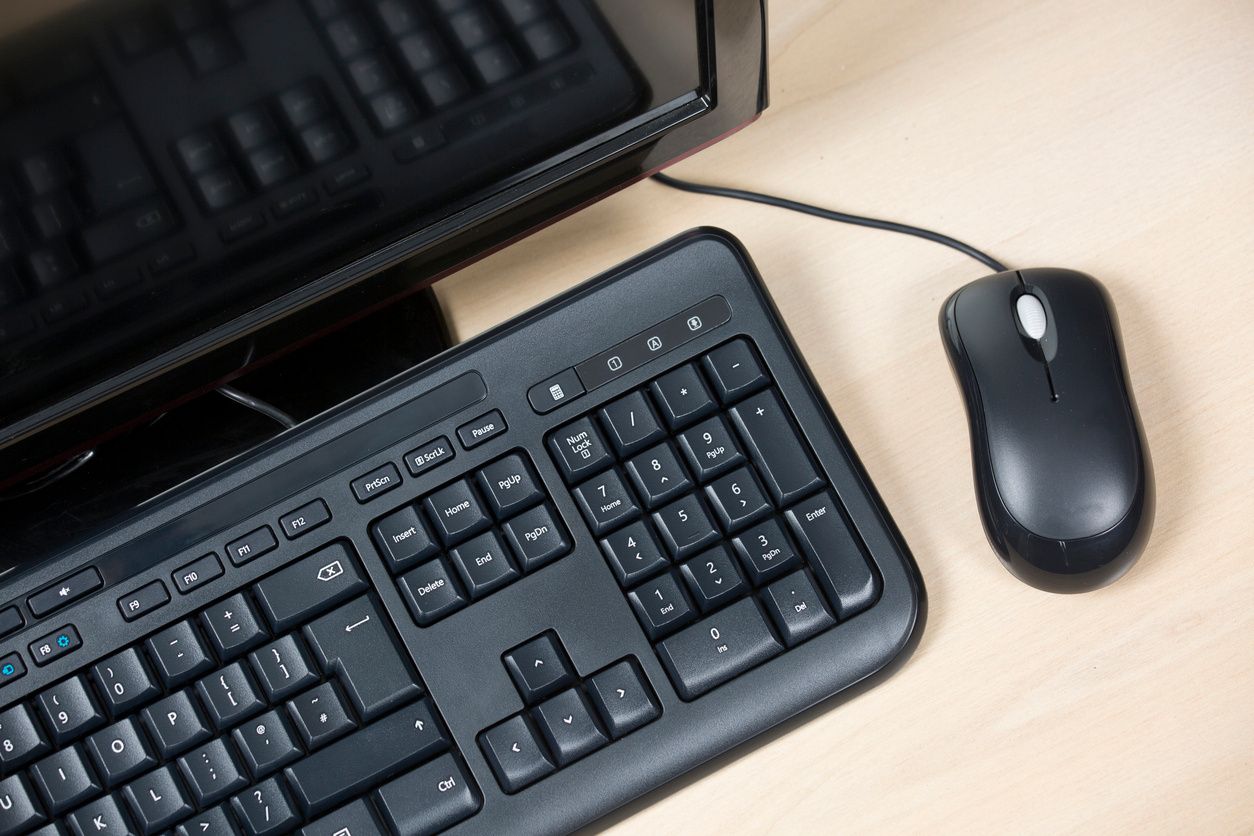 Black computer, keyboard and mouse on a desk