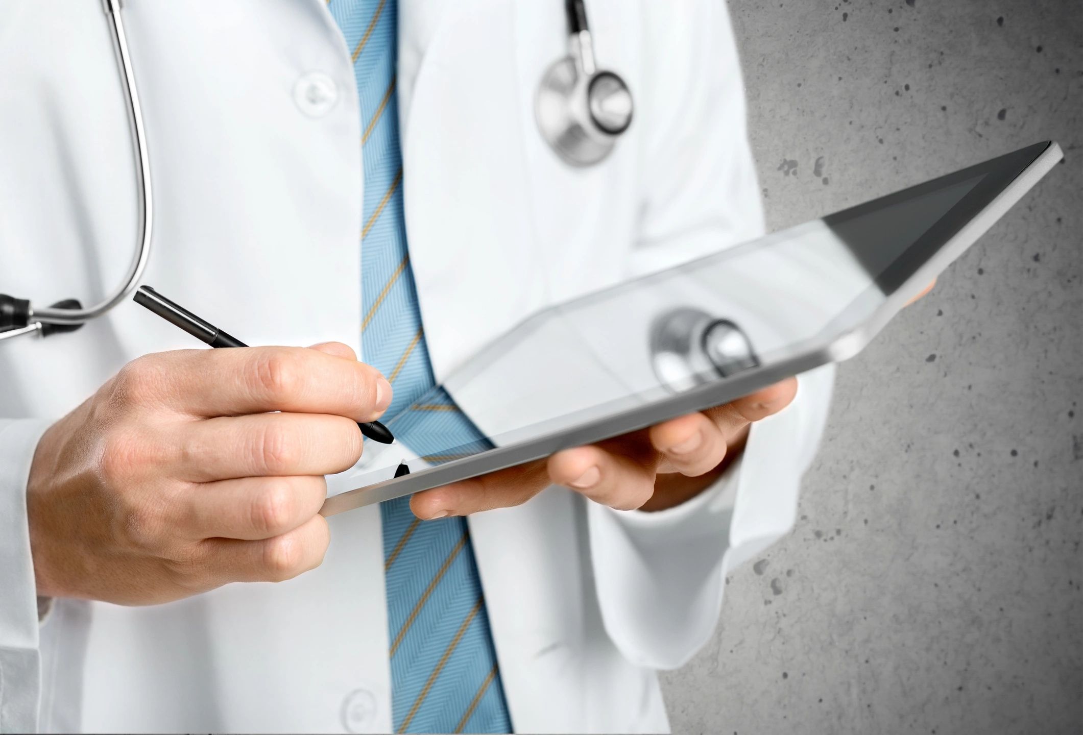Doctor holds a tablet and writes on it with a stylus