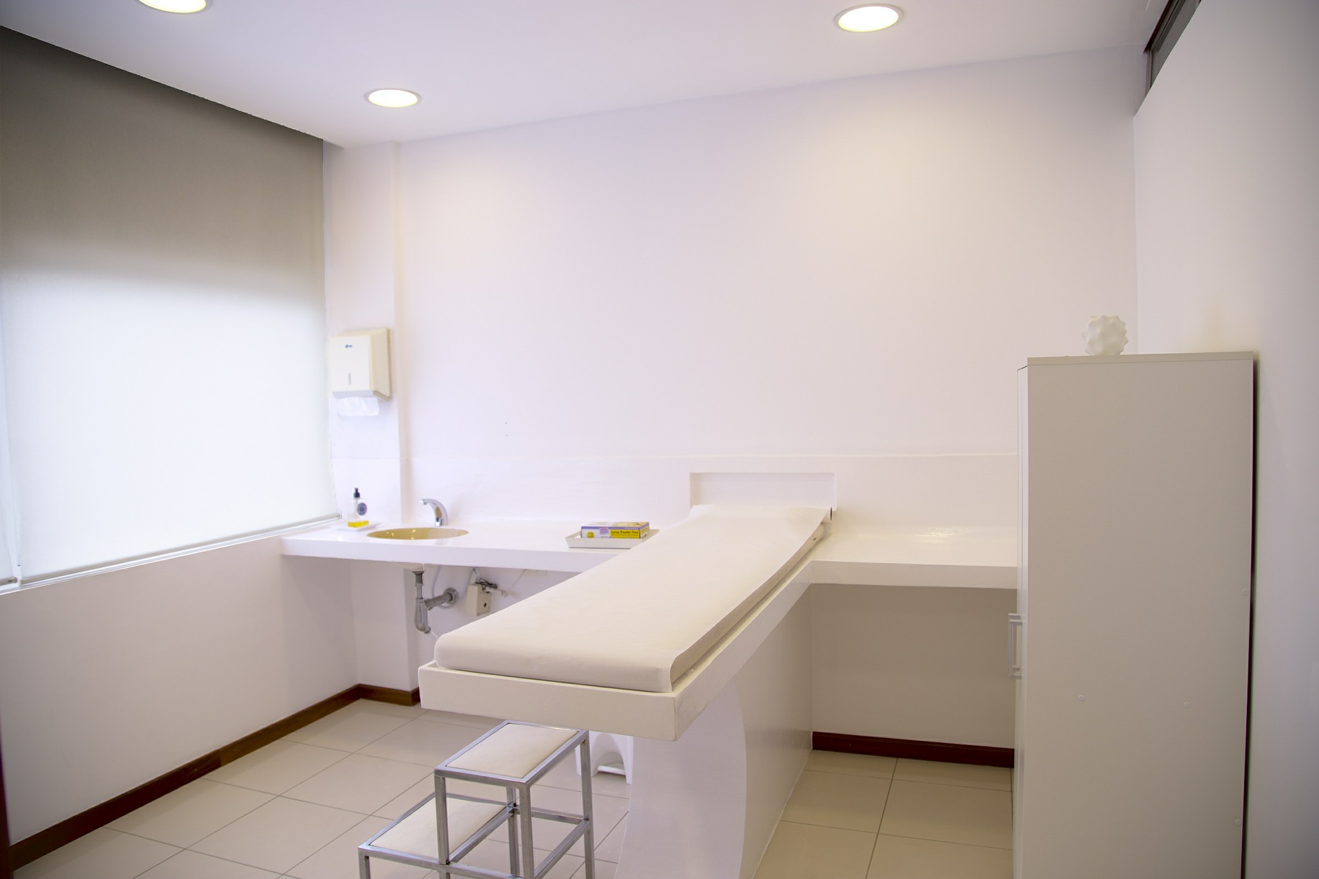Minimalist medical treatment room with all white walls