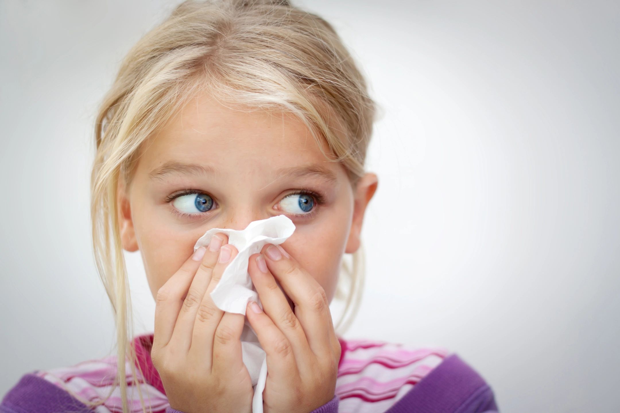 Girl holding a tissue to her nose